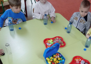 Dzieci wykonują grzechotki z butelek i koralików